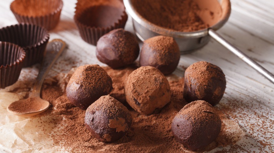 Chokoladetrfler drysset med kakaopulver ligger p et bord.